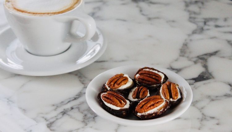 Halved dates stuffed with honey goat cheese and topped with pecan